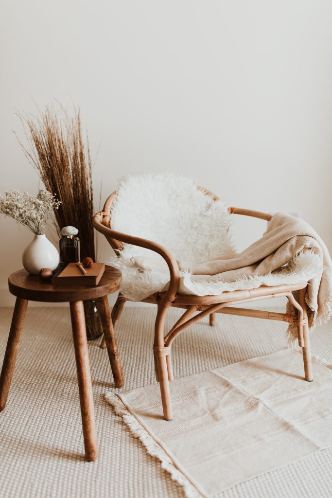 Rattan armchair with natural materials and a wooden side table in soft light